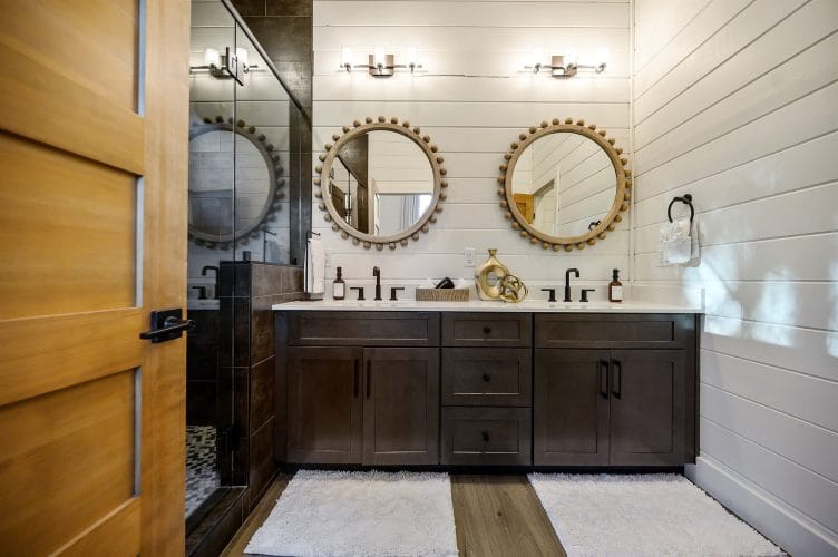 Double vanity with two round beaded-frame mirrors and a glass shower