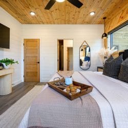 Same bedroom with a wall-mounted TV and a long console table