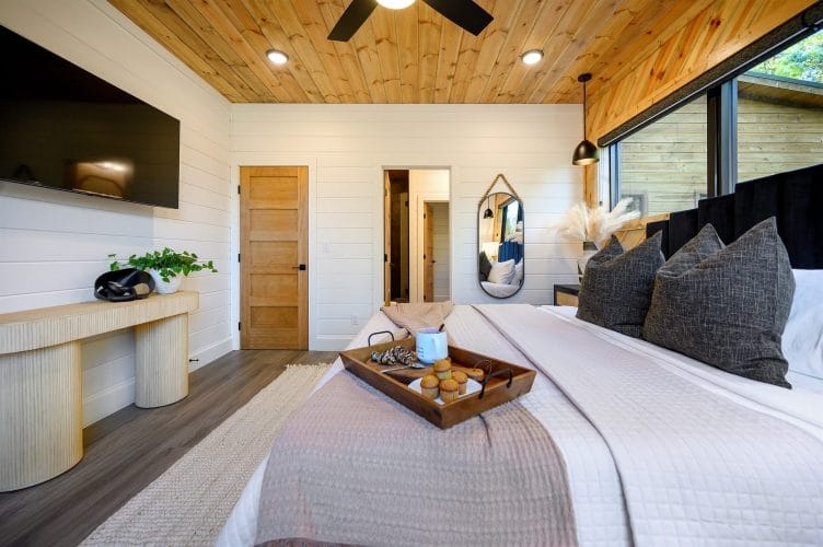 Same bedroom with a wall-mounted TV and a long console table