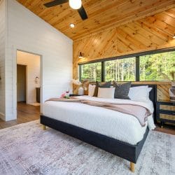 King bed under a herringbone pine accent wall with a long window