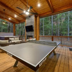 Ping pong table on the covered deck with the hot tub and seating beyond