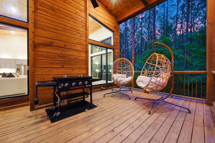 Two hanging wicker egg chairs and the griddle on the deck