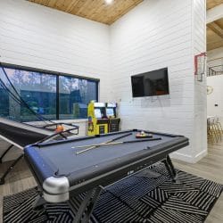 Game room with a pool table, a Pop-A-Shot basketball game, an arcade cabinet and a wall TV