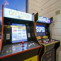 Pac-Man and Street Fighter II arcade cabinets beside a window
