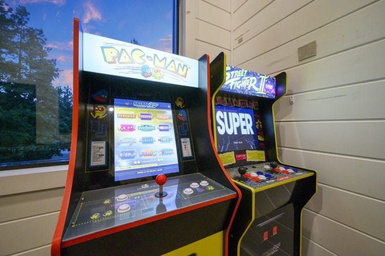 Pac-Man and Street Fighter II arcade cabinets beside a window