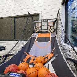 Pop-A-Shot basketball game with balls, beside a window