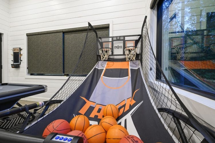 Pop-A-Shot basketball game with balls, beside a window