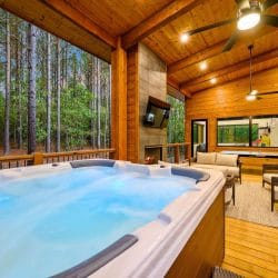 Hot tub on the covered deck with a ceiling fan overhead and seating beyond