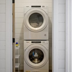Second stacked washer and dryer in a closet with a shelf