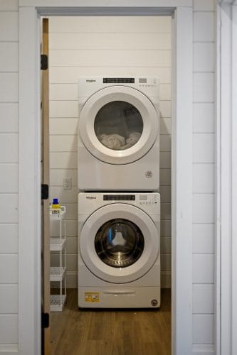 Second stacked washer and dryer in a closet with a shelf