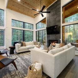 Living area with a tile fireplace running to the ceiling, white sofas and two chairs