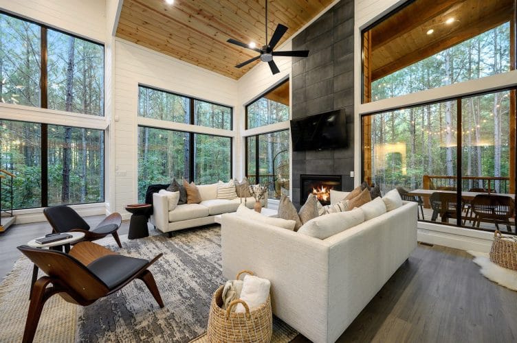 Living area with a tile fireplace running to the ceiling, white sofas and two chairs