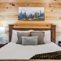 Bed with white bedding and a mountain print above
