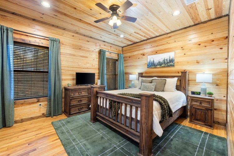 Wood-frame bed with a green rug and teal curtains
