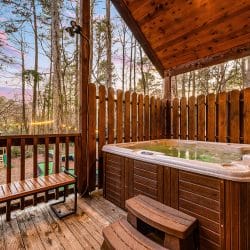 Hot tub on a fenced deck among the pines