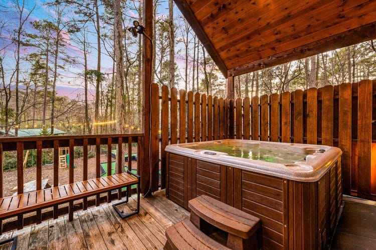 Hot tub on a fenced deck among the pines