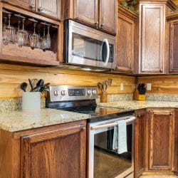 Kitchen range and microwave with a wine glass rack above