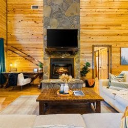 Stone fireplace with a TV above it, a cream sofa and a coffee table