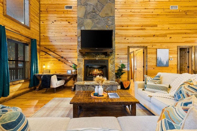 Stone fireplace with a TV above it, a cream sofa and a coffee table