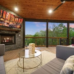 Gas fireplace with a TV above it and a glass coffee table with Jenga blocks