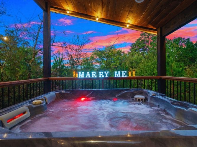 Hot tub with red lights under the covered platform and a lit marquee sign
