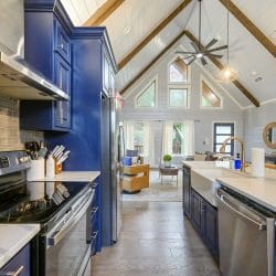 Long kitchen with navy cabinets and the living room beyond