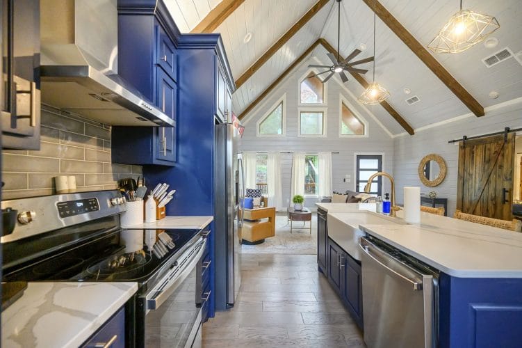 Long kitchen with navy cabinets and the living room beyond