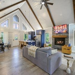 Sofa facing the fireplace and TV, with a dining table and the kitchen beyond