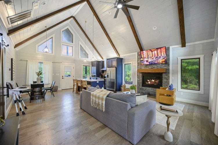 Sofa facing the fireplace and TV, with a dining table and the kitchen beyond