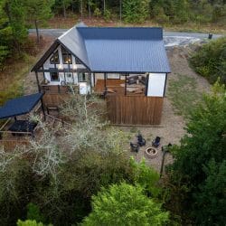 Aerial looking down at the cabin roof, the hot tub platform and the fire pit