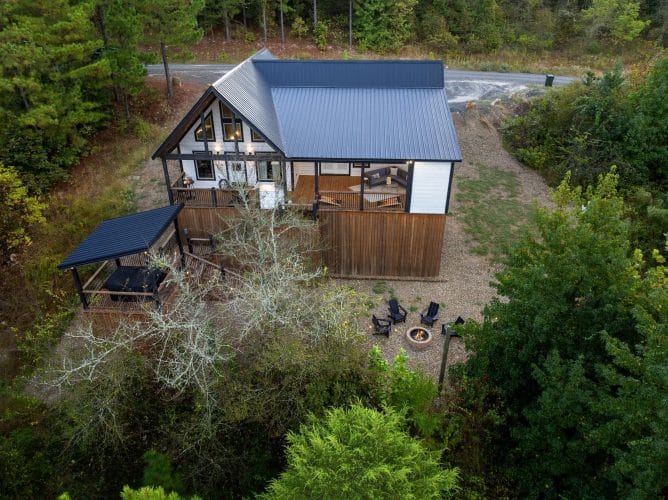 Aerial looking down at the cabin roof, the hot tub platform and the fire pit