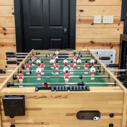 Foosball table at the loft railing in front of a black door