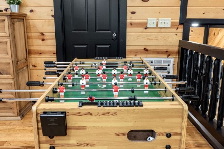 Foosball table at the loft railing in front of a black door
