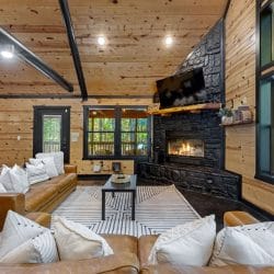 Living room from the side with the fireplace, windows and the dining area beyond