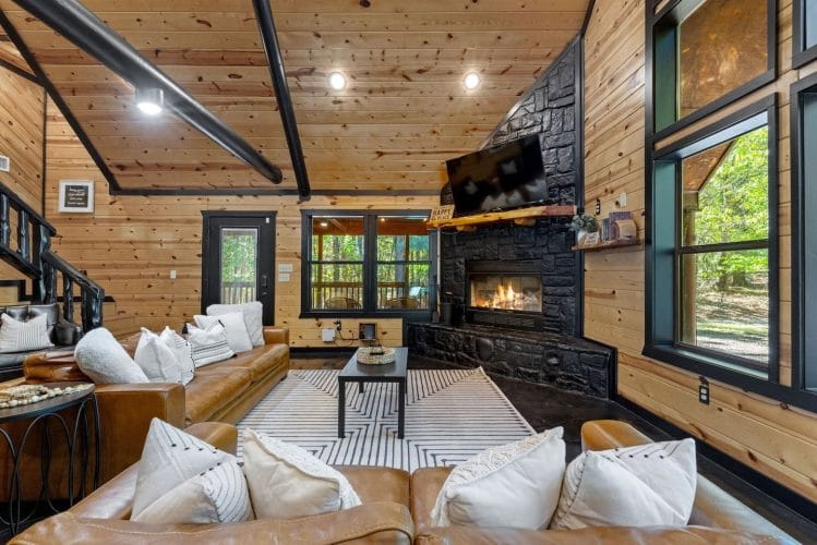 Living room from the side with the fireplace, windows and the dining area beyond