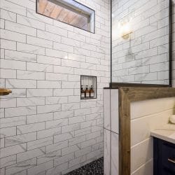 Shower niche with three amber bottles in white marble-look tile