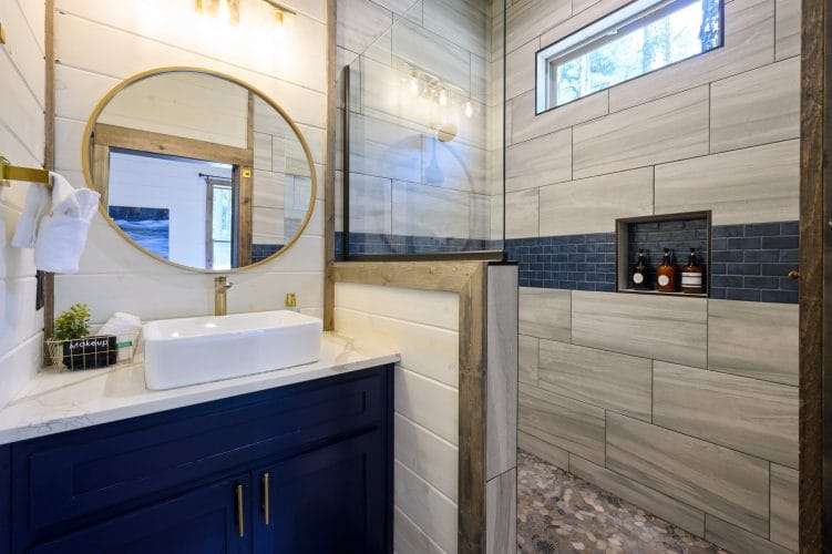 Blue tile above a rustic wood-framed edge in a bathroom