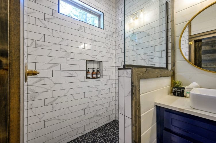 Shower niche with bottles in white marble-look tile