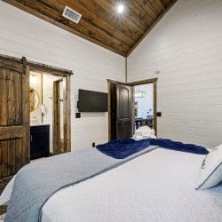Wall-mounted TV beside a dark wood door in a bedroom