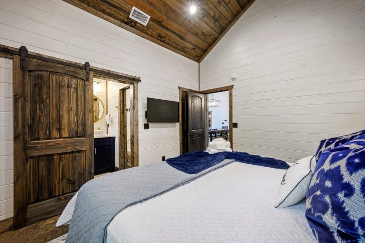 Wall-mounted TV beside a dark wood door in a bedroom