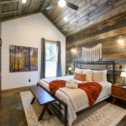 Bedside lamp and gray curtains beside a reclaimed wood accent wall