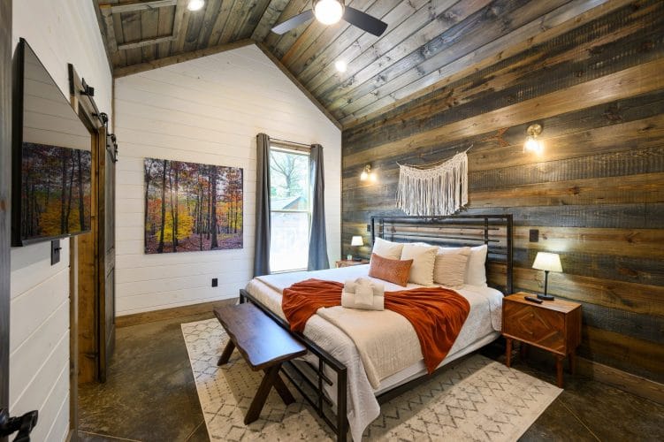 Bedside lamp and gray curtains beside a reclaimed wood accent wall