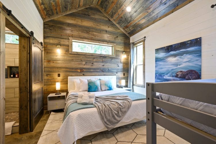 Headboard with aqua pillows against a reclaimed wood wall