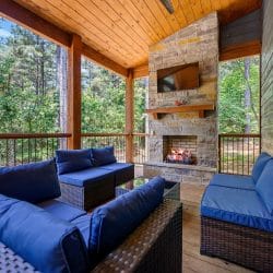 Porch railing and the corner of the stone fireplace with a blue cushion