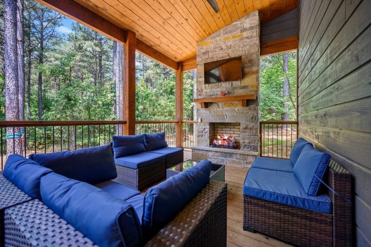 Porch railing and the corner of the stone fireplace with a blue cushion