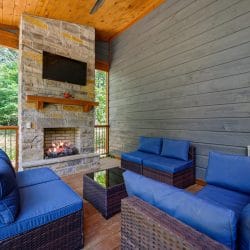 Gray cabin siding and a blue cushion on the porch