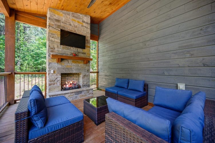 Gray cabin siding and a blue cushion on the porch