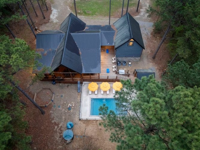 Aerial view of the deck, three yellow umbrellas by the pool and the metal roof