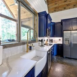 Gold faucet, an "Eat" sign, a utensil crock and a knife block against white tile