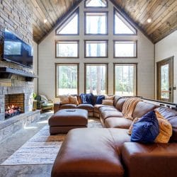 Leather sectional with a blue knit throw and pillows beside a window
